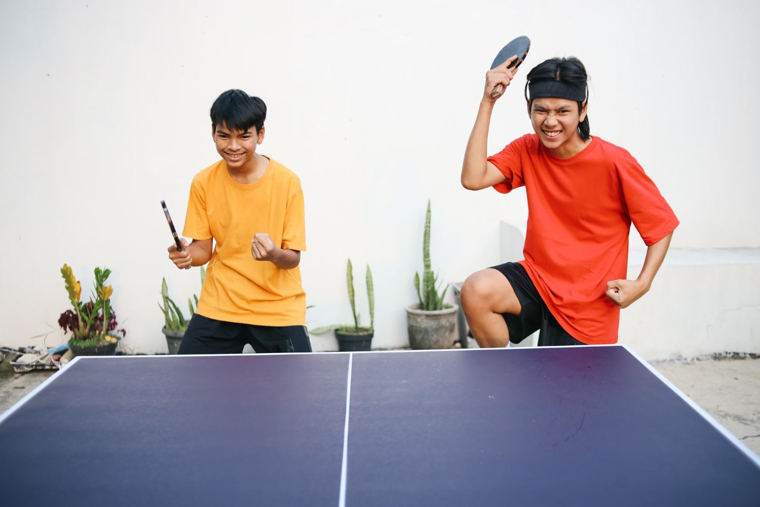 Young Asian Athletes Celebrating Victory With Raised Hands And Fists